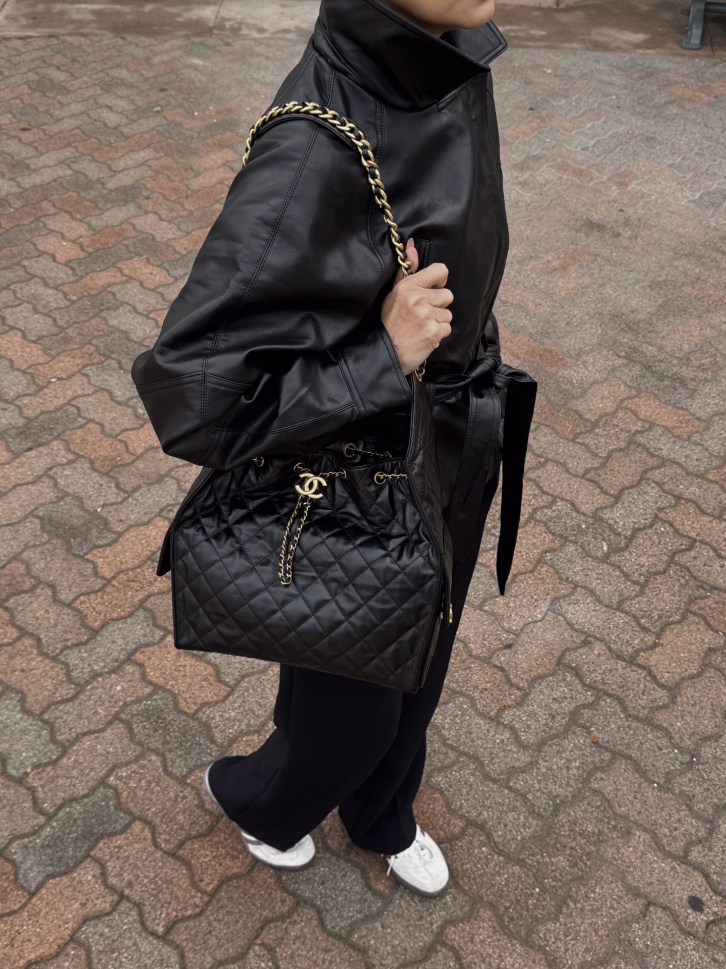 wearing a chanel 25 bag with an all black outfit