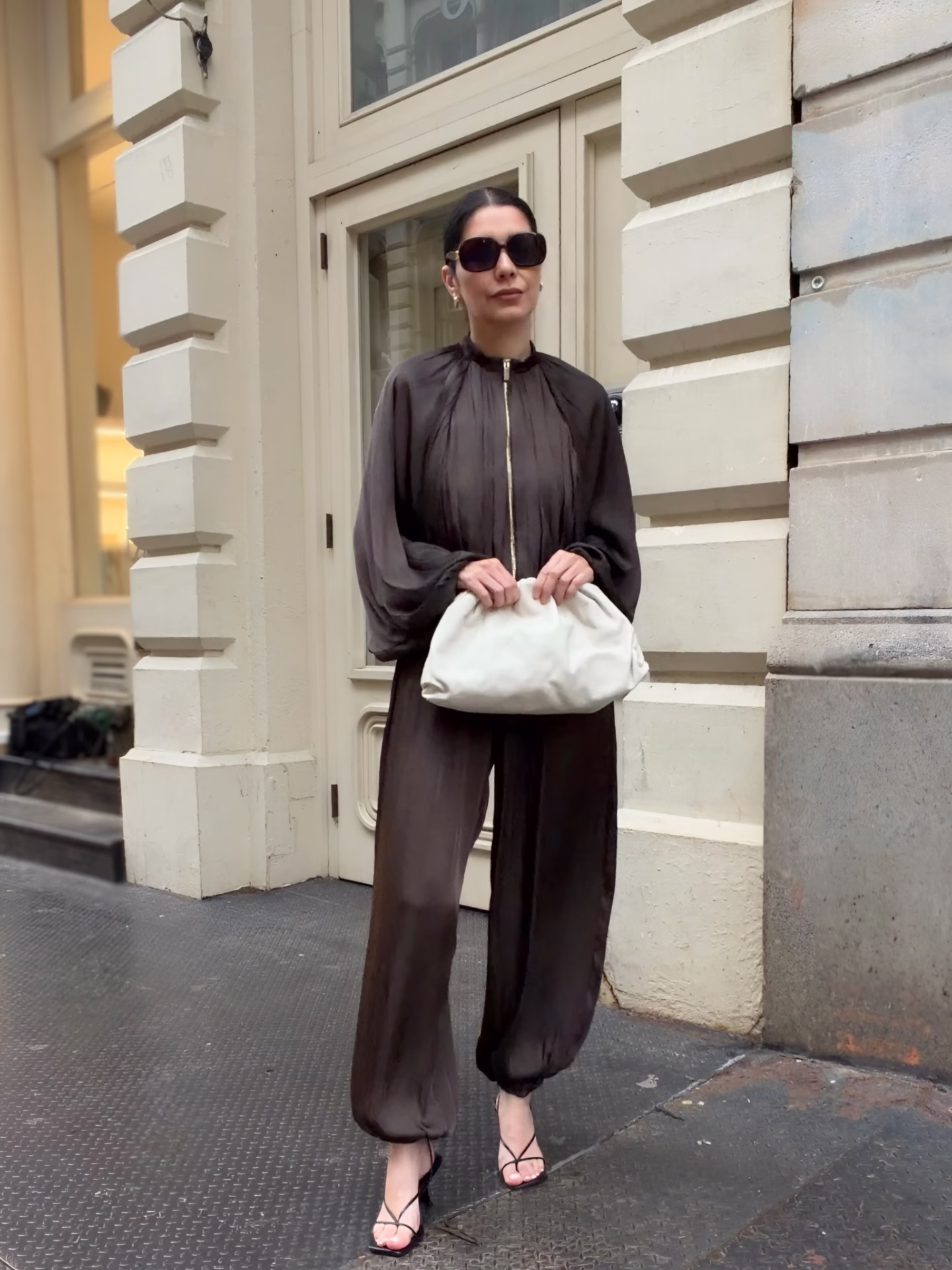 Army green Balloon hem pants and balloon hem top with black strappy heel sandals and a white bottega veneta clutch. The modern outfits reflect a chic spring fashion aesthetic, showcasing a blend of comfort and elegance perfect for any occasion. 