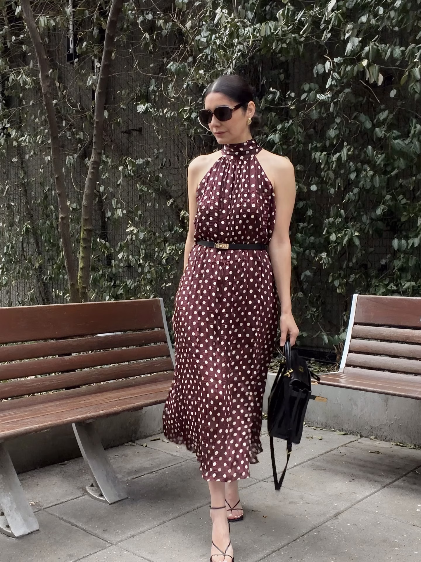 A Zara polka dot burgundy dress on size S and black sandals styled with a black Hermes Kelly 28 bag