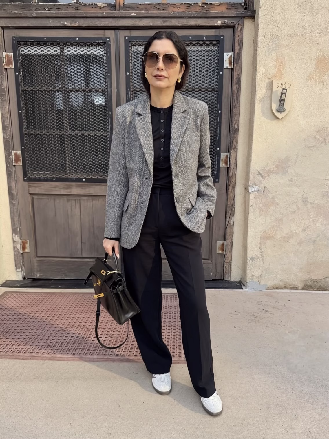 office outfit with sneakers: All black outfit with a grey blazer and adidas samba sneakers outfit wearing hermes birkin 28 bag black color